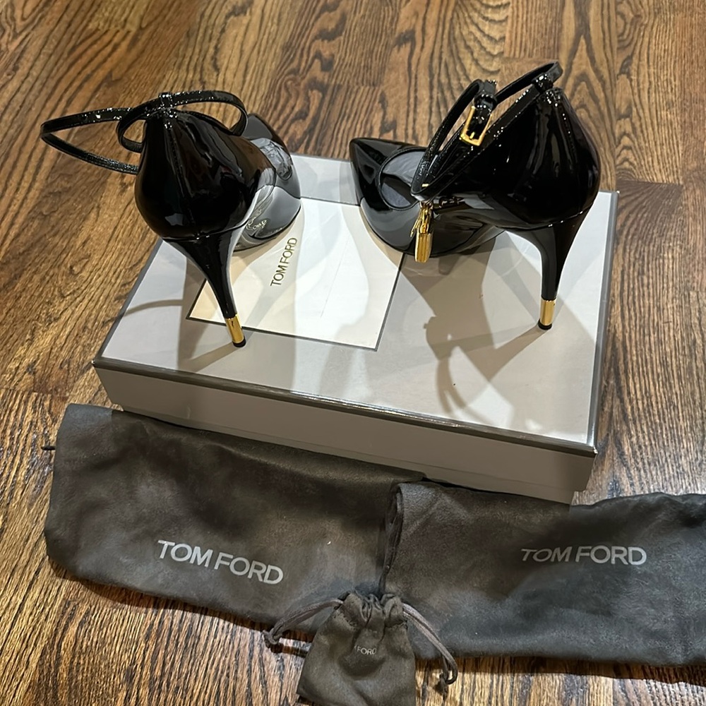 Tom Ford black patent 100 strapped heels with lock and key gold detail.